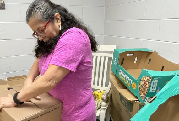 volunteer packing food into a box at the Y
